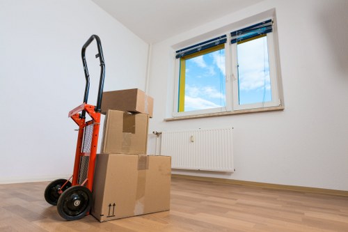 Movers carrying boxes from a flat in Highbury with stair access
